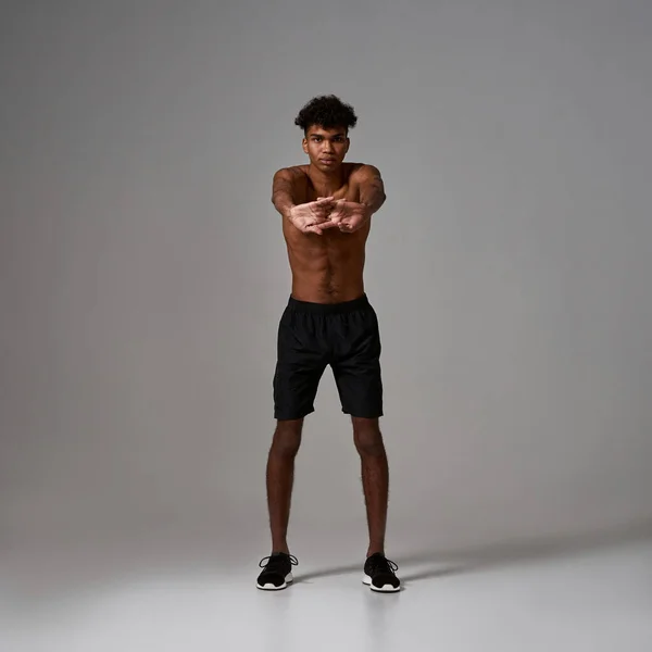 Black sportsman stretching before sport training — Stock Fotó