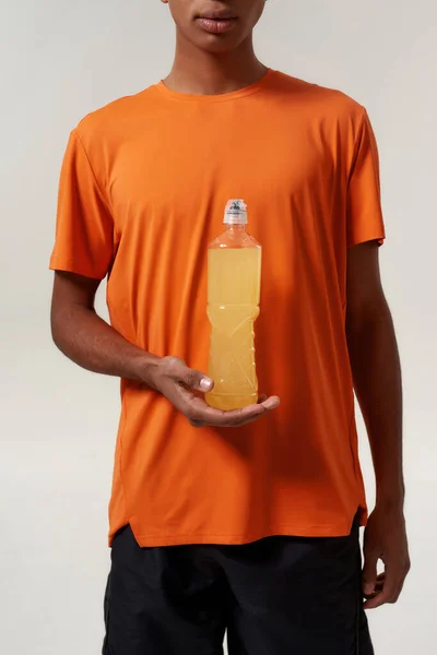 Pria kulit hitam memegang minuman olahraga kuning. — Stok Foto