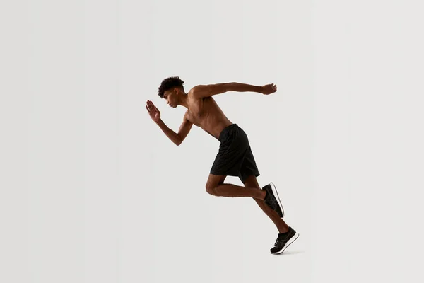 Boční pohled na černého soustředěného sportovce běžícího — Stock fotografie