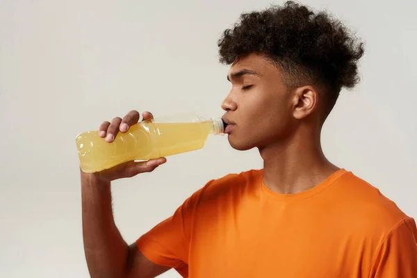노란 스포츠 음료를 마시는 흑인의 모습 — 스톡 사진