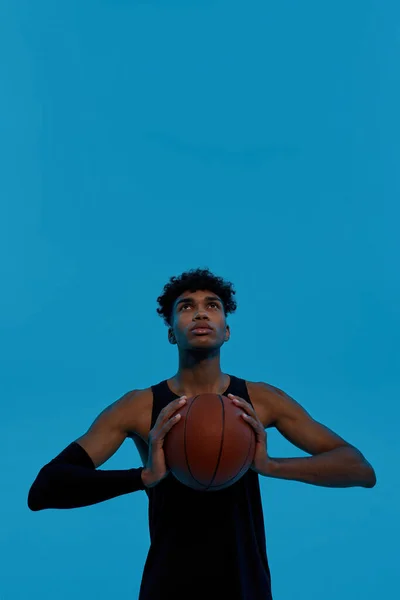 Kosárlabda játékos tartsa kosárlabda és nézz fel — Stock Fotó