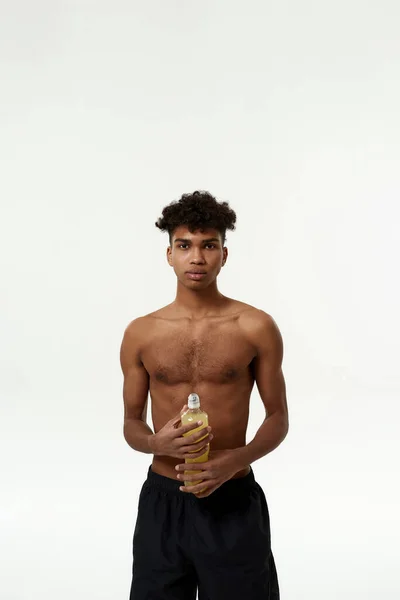 Sarı spor içeceği şişesi olan siyah sporcu. — Stok fotoğraf