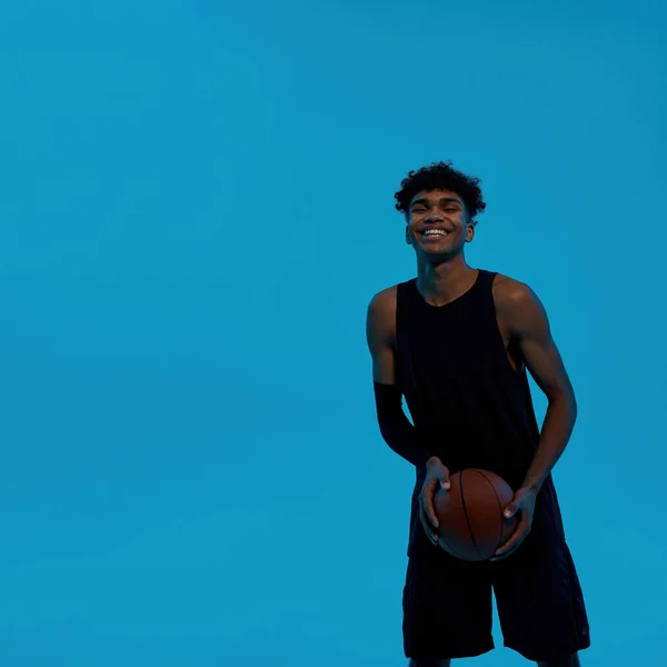 Fekete mosolygós sportember kezében kosárlabda — Stock Fotó