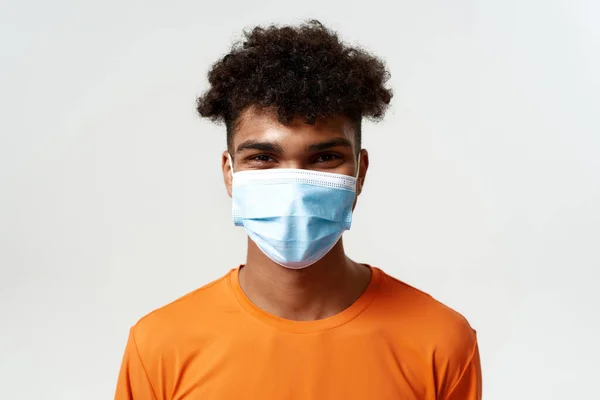 Hombre negro en máscara médica mirando a la cámara — Foto de Stock