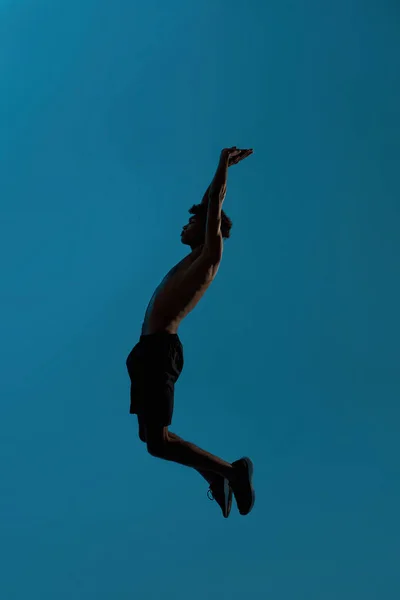 높이 뛰는 흑인 스포츠맨의 측면 뷰 — 스톡 사진