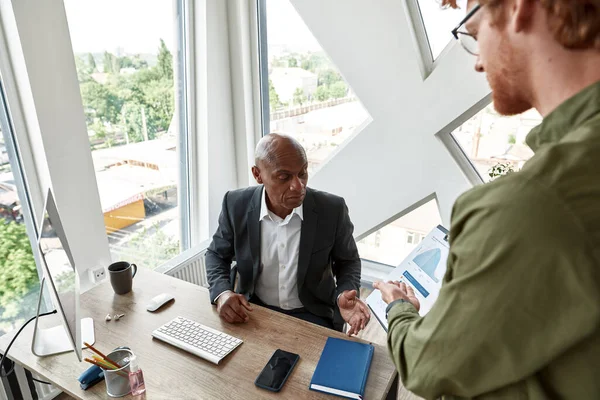 Man showing statistics to boss with skeptical face — Foto de Stock