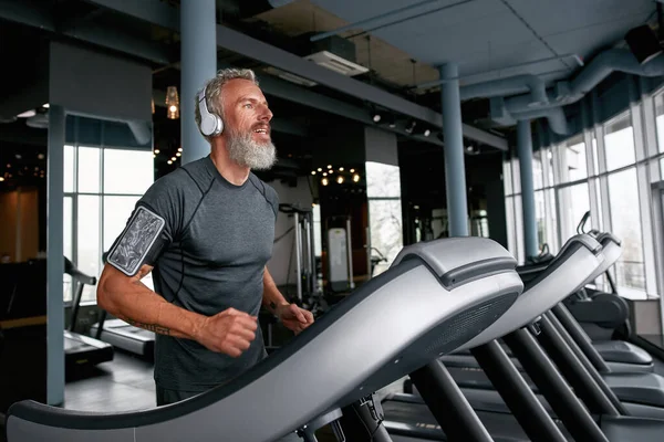 Aged man on treadmill, running over the top — Foto Stock