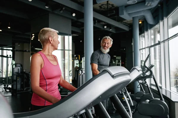 Indoor cardio workout. Elderly man and woman walking on treadmill — Foto Stock