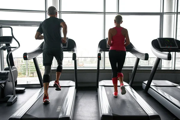 Senior people training on treadmills in gym — Fotografia de Stock