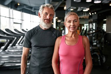 Lovely mature woman and handsome man in gym