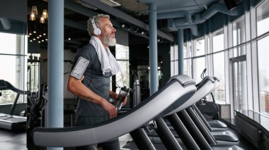 Tired man finished cardio exercises on treadmill