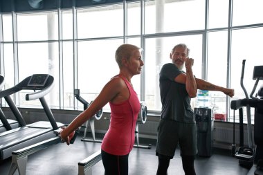 Middle-aged man and woman preparing for fitness class