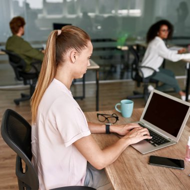 Caucasian girl type on laptop computer at work