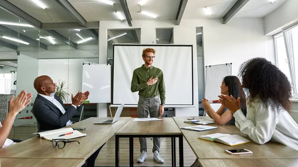 Team clapping in hands for employee at meeting — Stockfoto