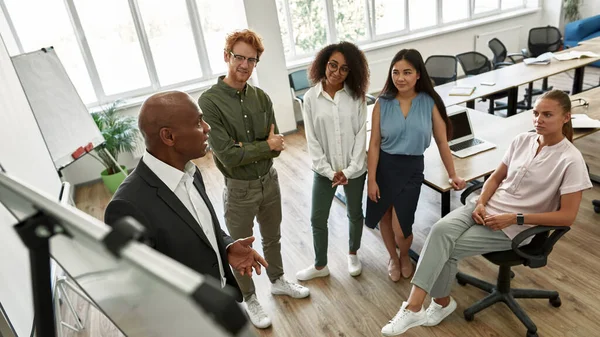 Leader performing before employees near board — Stockfoto