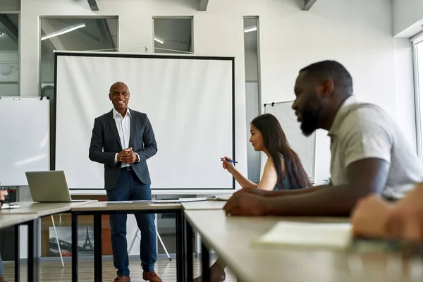 Smiling leader looking on employees at meeting — Stockfoto