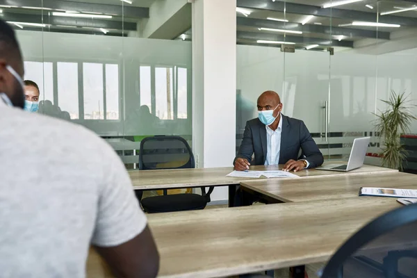 Boss listening and looking on black male employee — Stockfoto