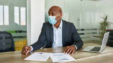 Boss in medical mask at company meeting in office