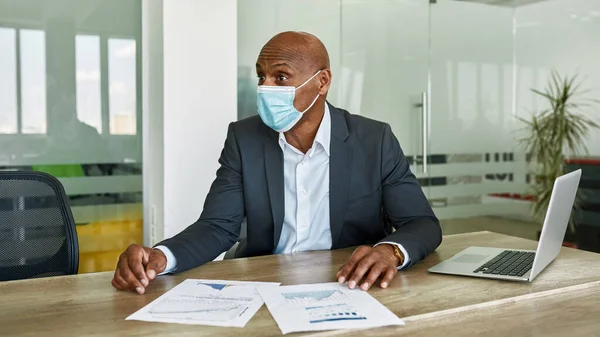Boss in medical mask at company meeting in office — Stock fotografie