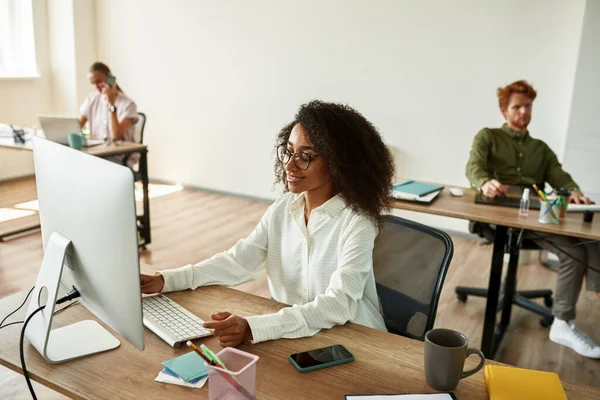 Black girl using computer while working in office — Stock Fotó