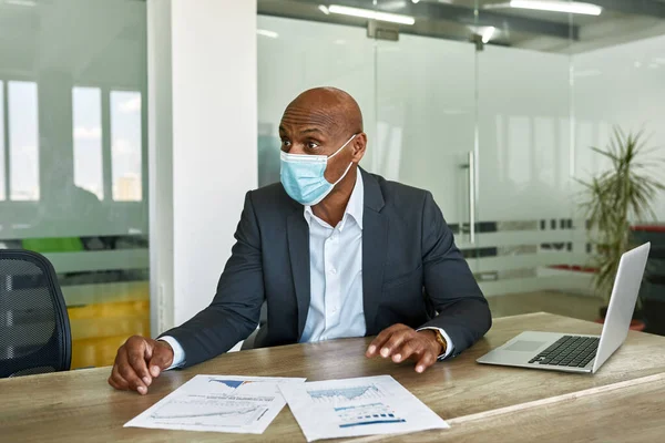 Leader in medical mask at corporate meet in office — Stock fotografie