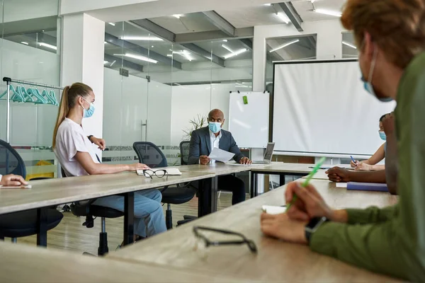Company leader looking on employees during meeting — Stock Photo, Image
