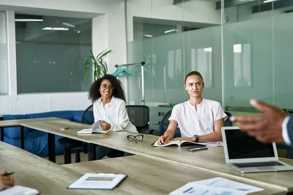 Young employees listening partial black male boss — Stock Photo, Image