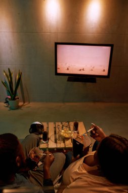 Siyah çift fast food yer ve televizyon veya film izler.