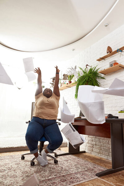 Радостная продавщица бросает бумажные документы в воздух