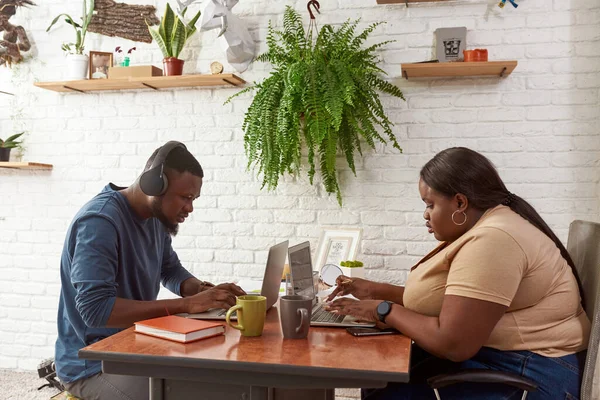 Homme et femme tapant sur des ordinateurs portables à la maison espace de travail — Photo