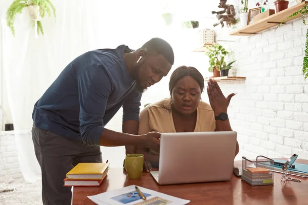 Mann schaut auf Laptop zu, während Mädchen unzufrieden arbeiten — Stockfoto