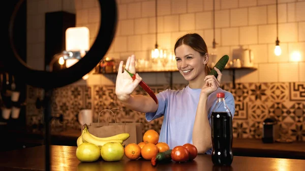 Frau hält Gemüse in der Hand und winkt für Video — Stockfoto