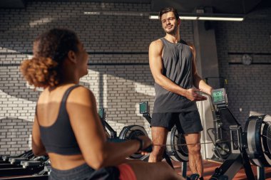 Spor salonunda siyah kız spor göstergeleri gösteren antrenör