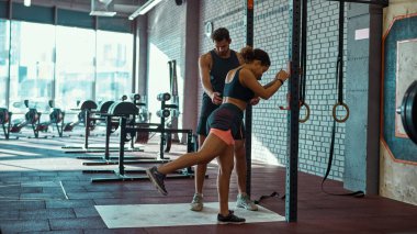 Spor merkezinde esneme hareketleri öğreten eğitmen kız.