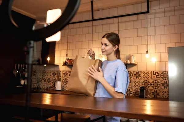 Mädchen hält Papiertüte mit Produkten für Video — Stockfoto