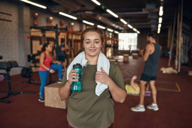 Kız, spor salonundaki insanlarla kameraya bak.