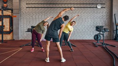 Spor salonunda kızlarla ısınan antrenörün arka planı.