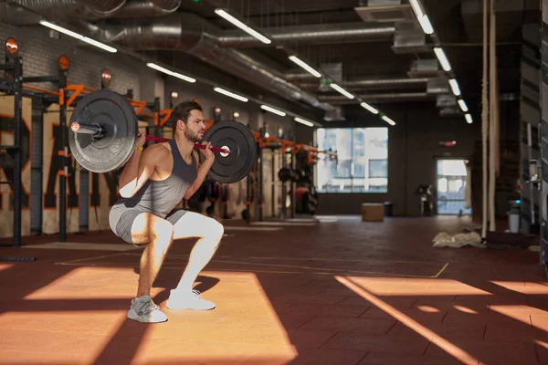 Uomo che fa sit up con pesi pesanti bilanciere in palestra — Foto Stock