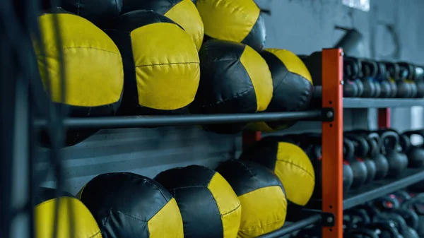 Conjunto de bolas desportivas e halteres nas prateleiras do ginásio — Fotografia de Stock