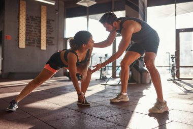 Antrenörüne bakan bir kız esnemesine yardım ediyor.
