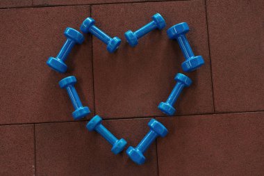 Spor salonunda yerde kalp şeklinde dambıllar var.