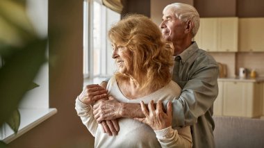 Üst düzey Kafkasyalı çift pencereden eve bakıyor.