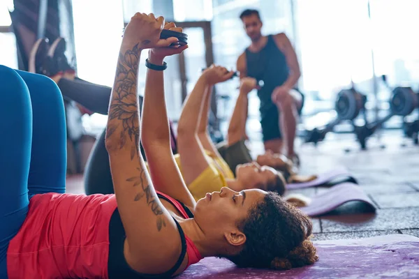 Mulheres se exercitam com discos de peso em tapetes de fitness — Fotografia de Stock
