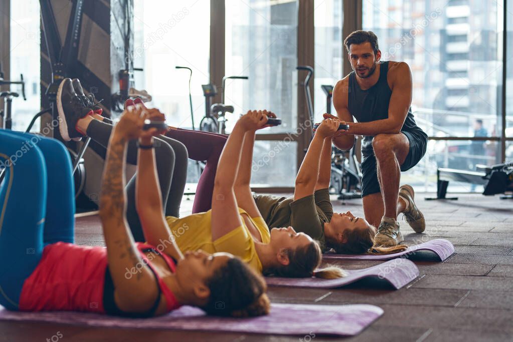 Male trainer look at women do exercise in gym