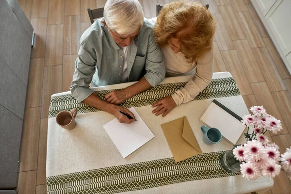 Vista dall'alto della donna guarda suo marito scrivere lettera — Foto Stock