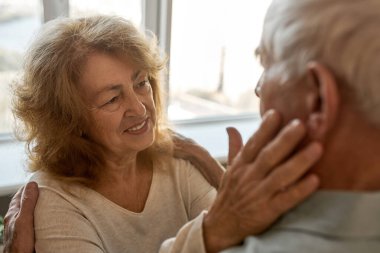 Yaşlı çift birbirine dokunuyor ve bakıyor.