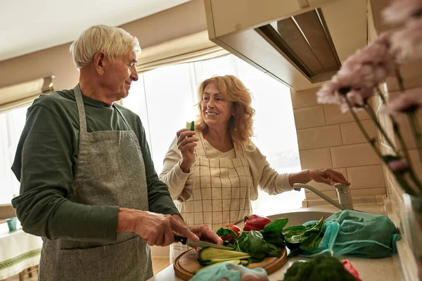 高齢者カップル調理サラダにホームキッチン — ストック写真