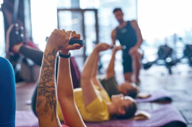 Spor salonunda ağırlık diskleriyle egzersiz yapan kızlar.