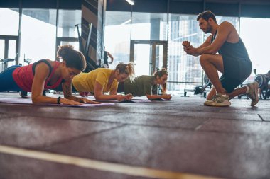 Antrenör spor salonunda kalas yapan kızlara bakıyor.