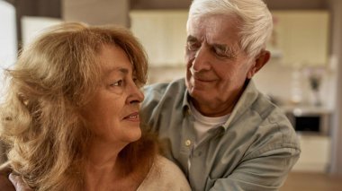 Evinde karısını kucaklayan bir adamın görüntüsü.